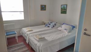 two beds in a small room with a window at Lomakoti Onnela in Haukipudas