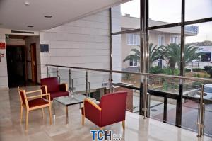 TCH Hotel في Lorquí: غرفة بها كراسي وطاولة وبلكونة