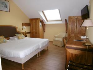 a bedroom with a bed and a desk and a window at Hôtel La Flore in Villefranche-sur-Mer