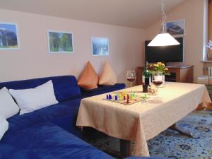 オーベルストドルフにあるFerienwohnung Schanzenblickのリビングルーム(テーブル、青いソファ付)