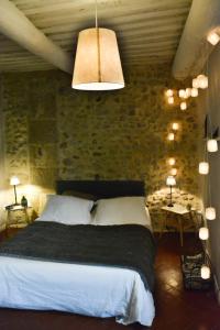 a bedroom with a bed and a stone wall at Alheuredusud in Violès