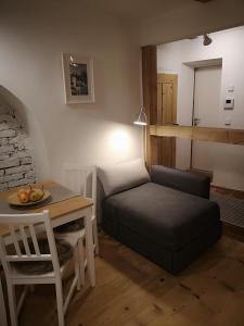 a living room with a bed and a table and a chair at Space Nr. 11 in Merano +6 photos