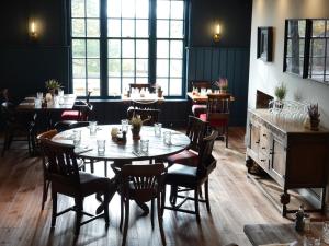 a dining room with tables and chairs and windows at The Devonport in Darlington