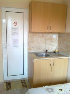 a small kitchen with a sink and a door at Guest rooms Rusalka in Kranevo