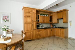 cocina con armarios de madera y mesa en Győrfi Apartmanház Zamárdi, en Zamárdi