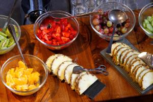 a wooden table topped with bowls of fruit and food at NOI Vitacura in Santiago