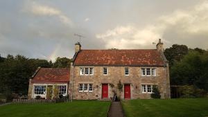 een groot bakstenen gebouw met een rood dak bij Ford Village Bed & Breakfast in Ford