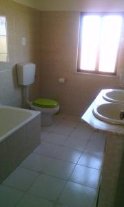 a bathroom with a green toilet and a sink at Villa Bartoni in Aljezur
