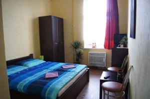 a bedroom with a bed with blue sheets and a window at Penzion Modrý Jelen in Vidnava