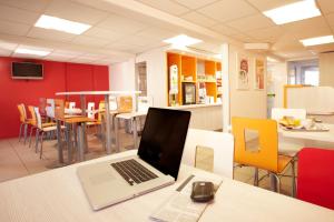 un ordinateur portable assis sur une table dans un restaurant dans l'établissement Premiere Classe Arles, à Arles