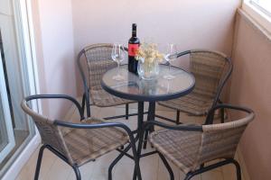 een tafel met een fles wijn en drie stoelen bij Nin Ždrijac 2 in Nin