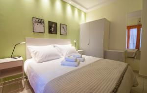 Smart living flat, Melenikou في سلانيك: غرفة نوم بسرير ابيض عليها مناشف