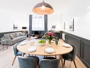 una sala da pranzo con tavolo e sedie di LivinParis - Luxury 3 Bedrooms République I a Parigi