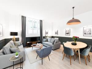 un soggiorno con divano, tavolo e sedie di LivinParis - Luxury 3 Bedrooms République I a Parigi