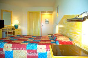 a hotel room with a bed and a desk at Hotel La Galleria in Le Lamentin