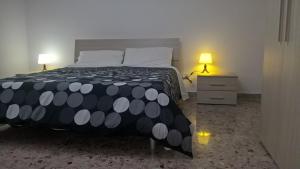 a bedroom with a bed with a black and white comforter at Ercole in riposo in Caserta