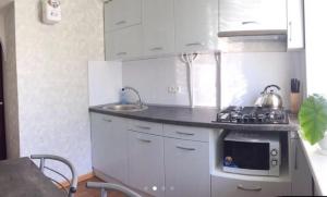 a small kitchen with a stove and a sink at Apartment Shevchenka 154 in Nikopolʼ