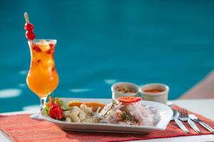 a plate of food on a table with a drink at Hotel Chavín in Barranca