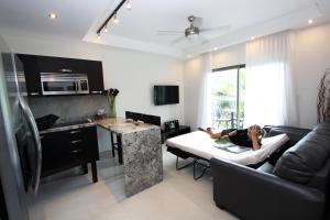 a woman laying on a couch in a living room at PACIFIC SUITES Boutique Hotel and Bistro in Jacó