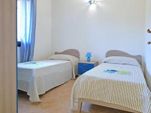 a room with two twin beds and a table at villette acquamarina Budoni in Budoni