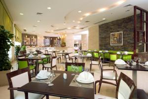 een restaurant met tafels en stoelen en een bakstenen muur bij Swiss Inn Teda Hotel & Aqua Park in Ain Sokhna