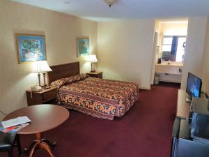pokój hotelowy z łóżkiem i stołem w obiekcie Swiss Village Inn w mieście Eureka Springs