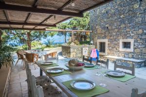 a table on a patio with a stone wall at Authentic Cretan Stone Windmill in Sitia