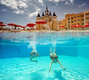 a person swimming in a pool in front of a swimming pool at Bahia Principe Fantasia Tenerife in San Miguel de Abona