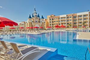 a large swimming pool with chairs and a resort at Bahia Principe Fantasia Tenerife in San Miguel de Abona