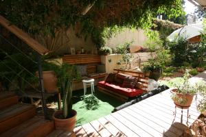 a patio with a couch in a garden with plants at Wonderful Garden Apartment in Tel Aviv