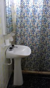 Un baño con lavabo y cortina de ducha. en Departamentos Silvia, en Santa Teresita