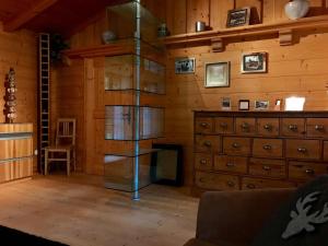 a room with a wooden wall with a glass book shelf at Haus Juna in Schönau am Königssee