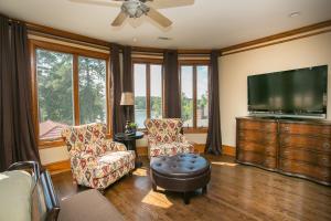 ein Wohnzimmer mit einem Flachbild-TV und 2 Stühlen in der Unterkunft The Villa in Greensboro