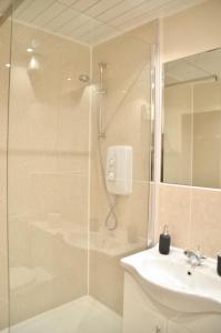 y baño con ducha y lavamanos. en Bala House, en Edimburgo