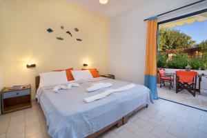 une chambre avec un lit avec des serviettes dessus dans l'établissement Kalypso Studios & Apartments, à Karavomylos 85 autres photos