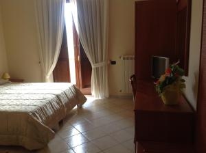 a bedroom with a bed and a tv and a window at Monte Degli Ulivi Country House in Mercato San Severino