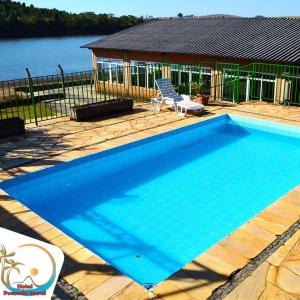 una gran piscina azul junto a una casa en Hotel Pousada Icaraí en Poços de Caldas