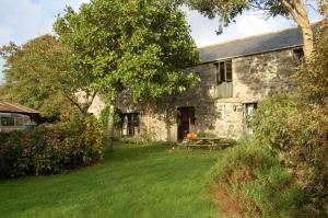 ヘルストンにあるThe Barn, Higher Boden, Manaccan, Helston, Cornwallの庭のピクニックテーブル付き石造りの家
