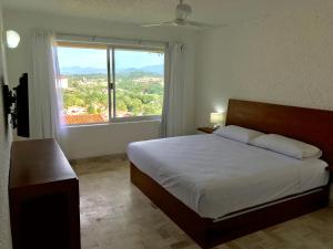 um quarto com uma cama grande e uma janela grande em Hotel Pacifica Departamento 2220 em Ixtapa