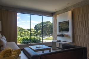 a living room with a couch and a large window at Posta Natural in Tandil