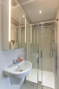 un bagno bianco con lavandino e doccia di The Perfect Stay Belfast a Belfast Altre 33 foto