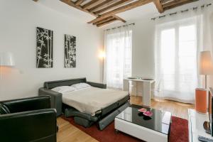 um quarto com uma cama, um sofá e uma mesa em Turenne Place Sainte Catherine em Paris