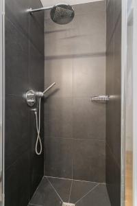 a bathroom with a shower with a glass door at Le Marais Place Sainte Catherine With AC in Paris +11 photos