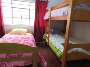 1 Schlafzimmer mit 2 Etagenbetten und 1 Bett in der Unterkunft Tinki Hostel in Cusco