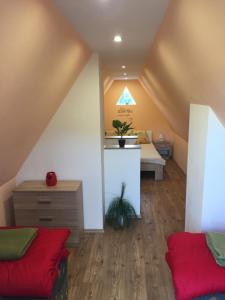 a attic room with a bed and a desk at Izabella Vendégház Somló in Doba