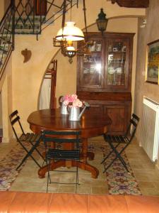 une salle à manger avec une table en bois et des fleurs. dans l'établissement the ancient sicilian house near zingaro reserve Scopello, à Scopello