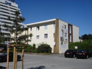 a building with cars parked in a parking lot at Haus Solymar App. 18 in Grömitz