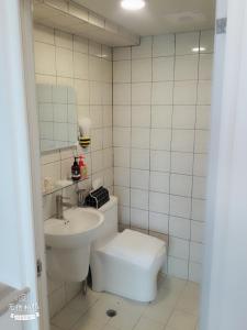 a white bathroom with a toilet and a sink at 成大窩 in Tainan