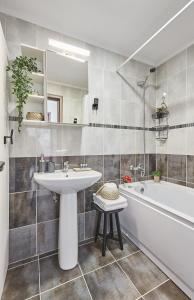y baño con lavamanos, bañera y lavamanos. en George Apartment Sinaia, en Sinaia