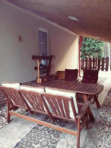 a porch with a wooden bench and a table at Borókahaus in Tata